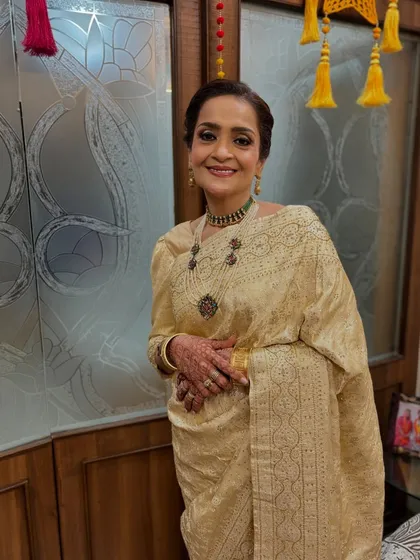This is the mother of the bride, looking absolutely regal for her daughter's reception. I styled her hair in a classic twisted bun that complements her elegant saree.