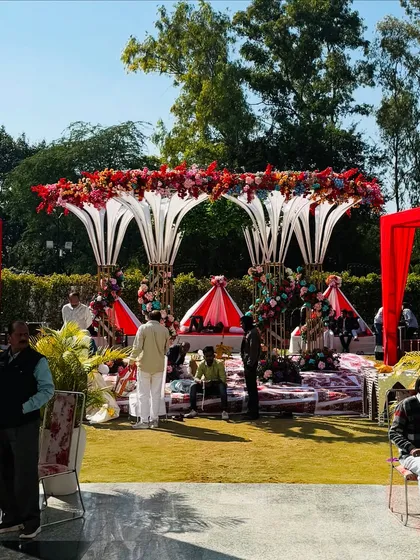 A wide view of the modern, multi-tiered mandap, showing the guest seating and the overall grand scale of the outdoor setup.