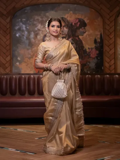 The timeless elegance of a golden tissue silk saree, paired with a classic makeup look and a gajra bun.