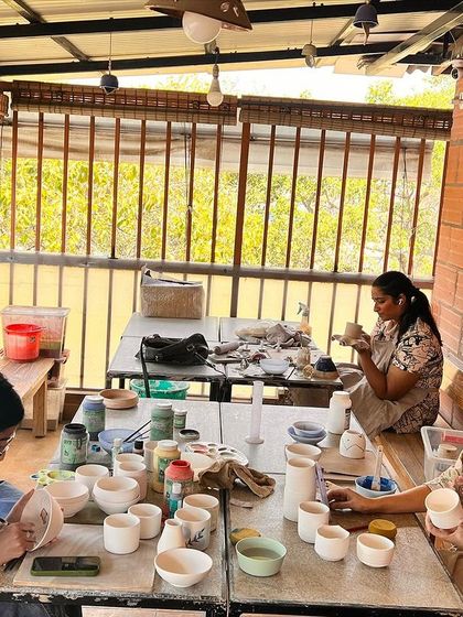 A glimpse of the glazing session, where students paint their bisque-fired pots. This is one of the most exciting parts of the pottery process.