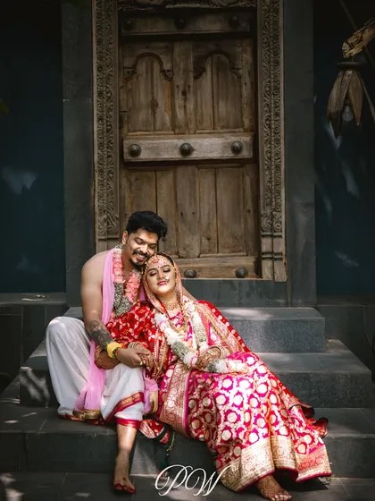 A quiet moment of love after the ceremony. The bride and groom, in their beautiful traditional attire, find a peaceful spot on the steps, showcasing the calm after the grand celebration.