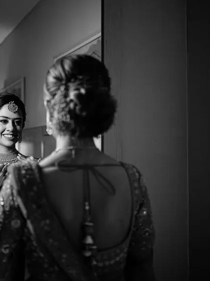 A timeless black and white portrait of the bride looking at her reflection. This introspective shot is full of emotion and classic beauty.