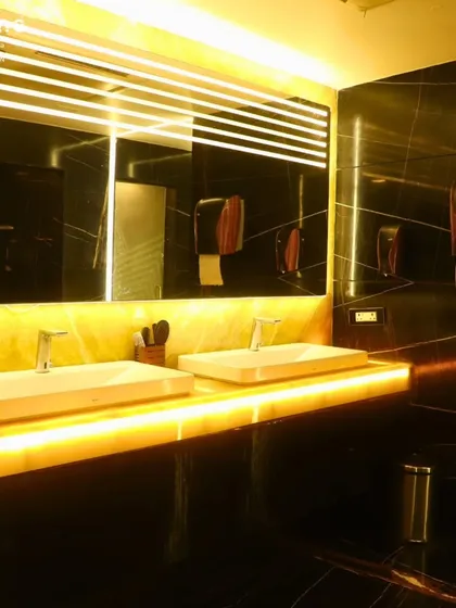 A look inside my premium wet area, featuring a backlit onyx countertop and modern vessel sinks. I prioritize cleanliness and a high-end finish in all my facilities to ensure your entire experience, from workout to wind-down, feels exceptional.