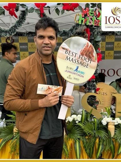 A happy participant at the Bawa Juhu Juniorthon, holding a sign for our "Best Foot Massage." We were proud to support the community and provide a touch of wellness at the event.