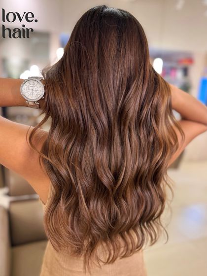 The full back view of our 'Nutella' global colour, showcasing the deep, chocolatey-hazelnut shade on long, beautiful waves.