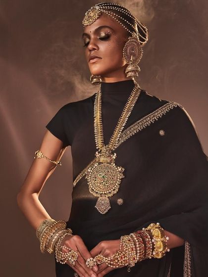 An ethereal shot for Reasons Jewellery, where the model is adorned in multiple layers of bespoke pieces, including necklaces, bangles, and a headpiece, showcasing the brand's opulent style.