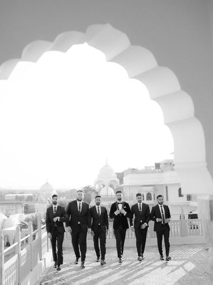 A stylish, architectural shot of the groom and his groomsmen. Framed by a large archway, this black and white photo has a cinematic and powerful feel.
