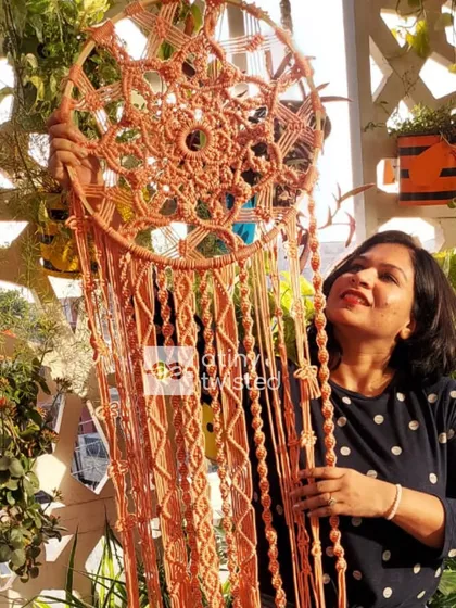 This is me with one of my largest creations, a 4-foot-tall macramé dreamcatcher. A client wanted a grand statement piece for her living room, and I was so excited to bring her vision to life. The intricate, oversized design adds so much texture and elegance to a large wall.