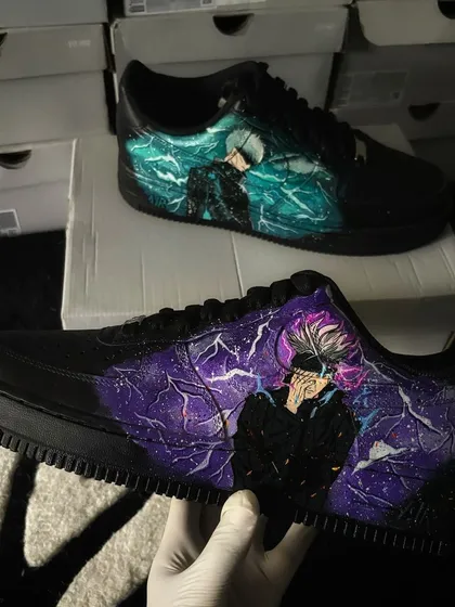 The Gojo custom sneakers held up, displaying the vibrant colors against the black shoe.