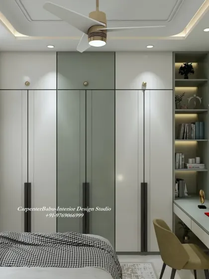 A full view of the bedroom, showing the wardrobe with long, elegant handles and the well-lit study corner. The design is both practical and aesthetically pleasing.
