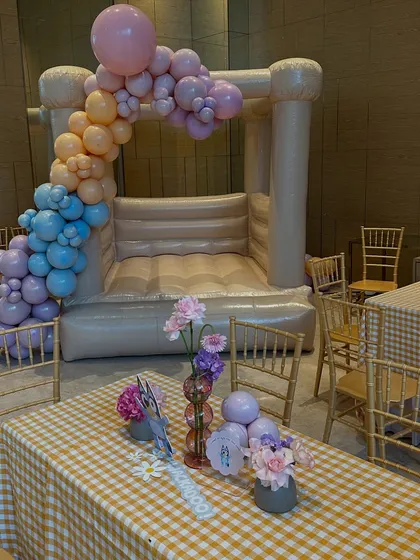 A view across the adults' table towards the bouncy castle, showing how the entire space was designed for both elegance and fun.