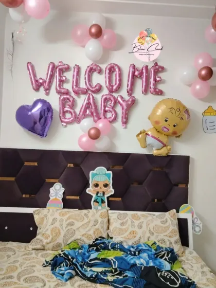 A simple 'Welcome Baby' girl room decoration with foil letters and character cutouts.