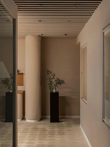 The corridor in our 'Crème' wellness center project is designed to be a seamless, soothing experience. The curved walls, monochrome beige palette, and soft lighting guide visitors through the space, creating a sense of calm and restrained luxury.