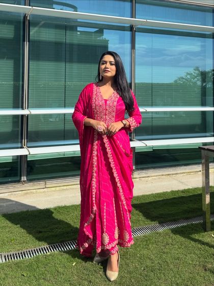 A full-length shot of my pink draped suit. The modern draping gives a contemporary twist to a classic Indian outfit, making it comfortable and stylish for hosting.