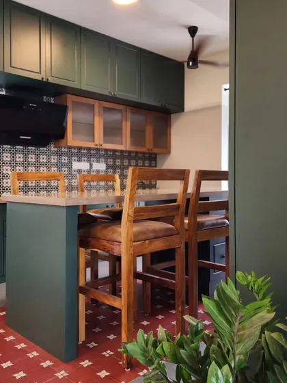 An open kitchen with a breakfast island, finished in a deep forest green. This design shows our ability to integrate bold color with natural wood tones and patterned tiles, creating a warm and inviting hub for family life.