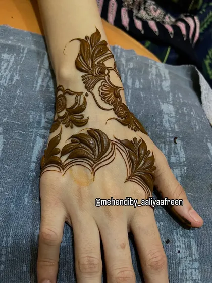 The complete view of the minimalist leaf design, showing its graceful placement on the hand and wrist.