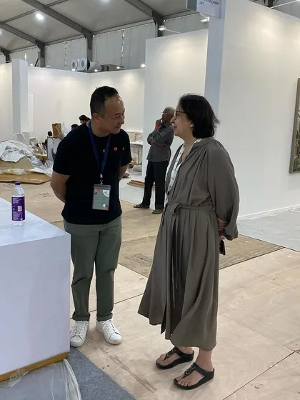 A candid moment of conversation during the busy art fair setup.