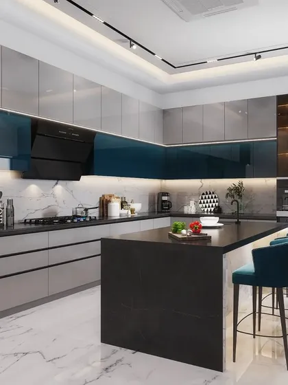 The kitchen is the heart of the home, and we design them to be both beautiful and highly functional. This modern kitchen features a sleek island with a breakfast bar, dual-tone cabinetry in teal and grey, and integrated high-end appliances, all set against a classic marble floor for a touch of timeless luxury.