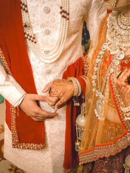 A detail shot of Rohit and Neha holding hands during their wedding ceremony. This classic photo symbolizes their union and the start of their new life together.