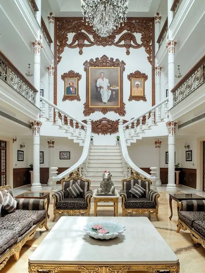 A full view of the living area, capturing the scale of the triple-height space, the intricate carvings, and the portraits of three generations of the family, which we integrated into the design.
