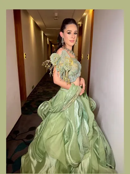 A unique, structured green gown by Sulakshana Monga, paired with statement jewellery for a high-fashion look.