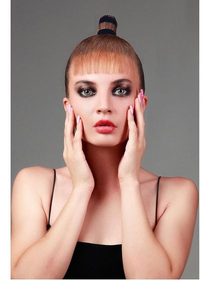 A high-fashion editorial portrait with a model in a unique hairstyle, showcasing a bold and artistic beauty look.