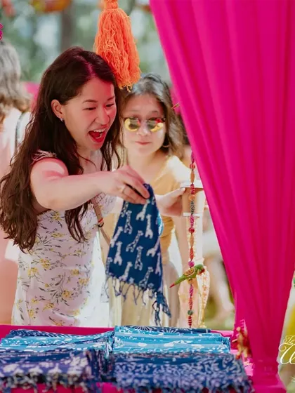 Interactive stalls are a great way to engage guests. At this Rajasthani Mela-themed Haldi, guests could pick out traditional bandhani scarves as wedding favors.
