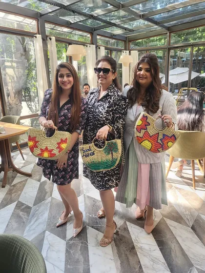 Three happy guests showing off the beautiful straw bags they painted themselves. At my parties, everyone leaves with a unique, handmade party favor that they can actually use and cherish.