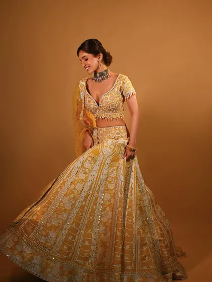 A full-length shot showing the beautiful twirl of the lehenga. The makeup is designed to look stunning both up close and from a distance.