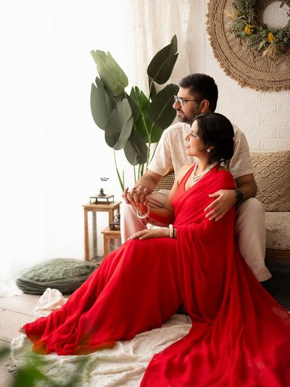 A quiet, romantic moment for the couple, looking out the window together. The red of her dress adds a beautiful pop of color to the neutral set.