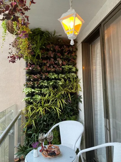 We transformed this compact apartment balcony into a cozy, private retreat. A dense vertical garden provides a lush green backdrop, perfectly complementing the small bistro table for a quiet evening with wine and conversation.