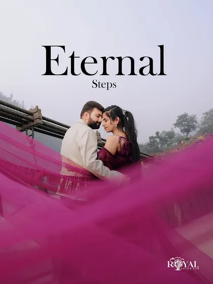 A dramatic and romantic shot of a couple embracing on the bridge, with the bride's magenta gown flowing in the wind.