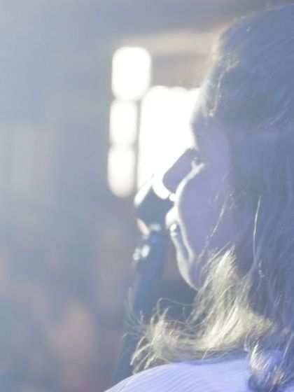 An atmospheric shot capturing a singer lost in the music, with the stage lights creating a magical moment. This is the magic of live performance.