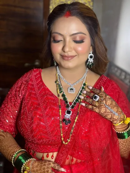 A close-up of the red reception look, showcasing the flawless makeup and statement jewelry.