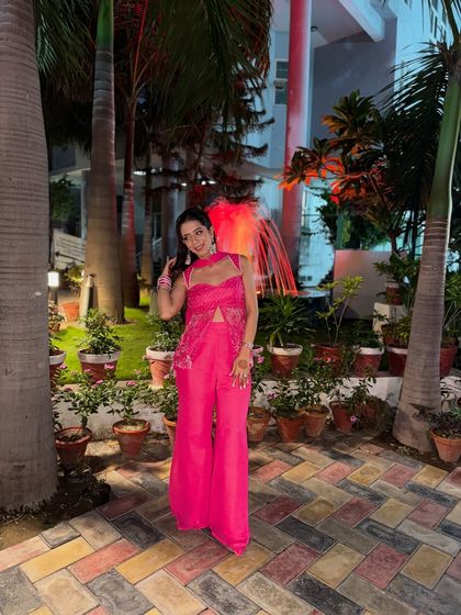 A full-length view of my self-designed pink outfit. The wide-leg pants and embroidered top create a modern and chic silhouette, perfect for a festive party.