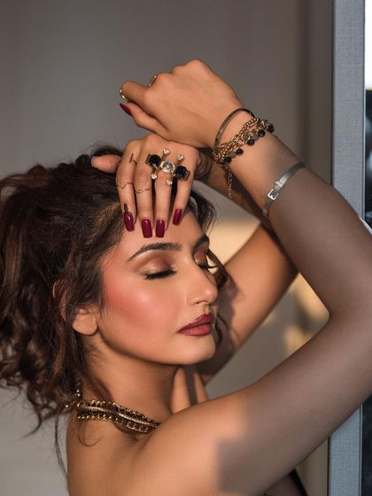 A close-up portrait using soft, natural window light. This intimate shot focuses on the model's expression and the delicate details of her accessories.