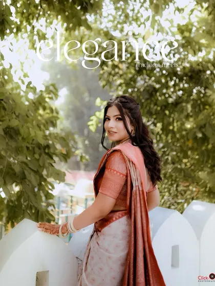 An elegant outdoor portrait of a woman in a traditional red and white banarasi saree. The natural greenery and soft light create a timeless and graceful look for this pre-wedding photoshoot.