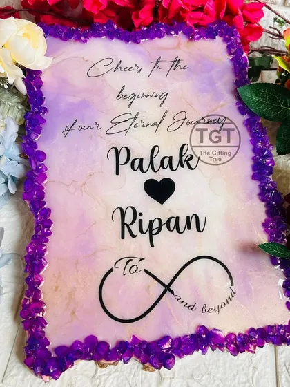 A clear shot of the invitation itself, showing the custom quote, names, and infinity symbol on a purple and white marbled background.