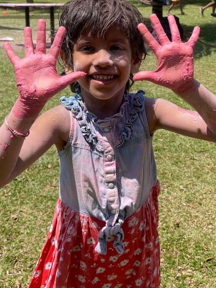A young participant showing off her colorful hands during our Holi festival. It was a day for messy, loud fun and making memories that will last long after the colors fade.