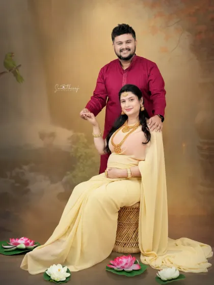 A beautiful couple portrait showcasing a traditional saree look. The soft lighting and serene expressions highlight the love and connection between the expecting parents.