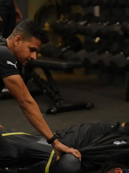 A hands-on approach to injury reduction. I'm assessing and assisting an athlete with a passive stretch, ensuring they are recovering properly and maintaining flexibility to prevent strains.