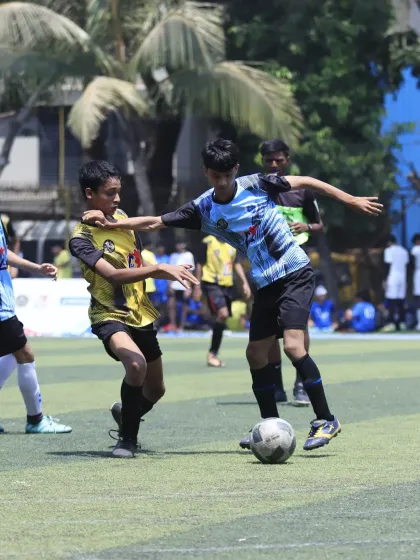 An intense duel for the ball. One of our players uses his body to shield the ball from an opponent, demonstrating key defensive and possession skills.