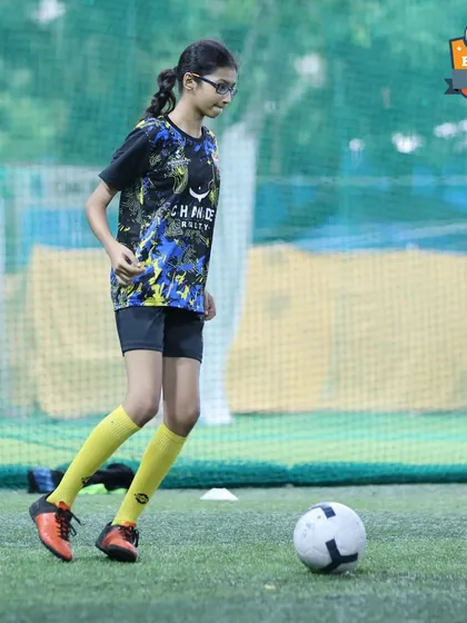 A young female player focused during a training session. Our programs and tournaments provide a clear pathway for girls to develop their football skills.