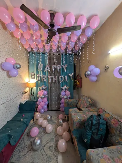 Another angle of the birthday room, highlighting the balloon flower arrangements on the wall and loose balloons on the floor.