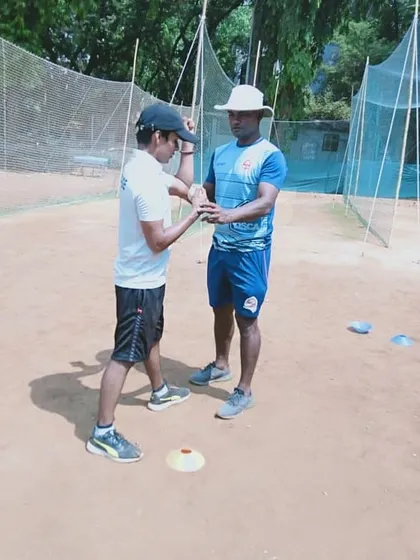 Working closely with a young bowler to refine his action. I am checking his arm position and wrist release to help him gain more control and speed.