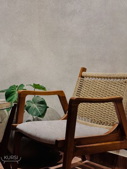A stunning teak wood armchair with a woven back and upholstered seat, blending comfort and elegance. It's a functional piece of art designed for modern and classic interiors.