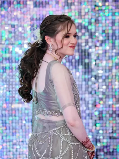 This side profile highlights the elegant braided ponytail hairstyle, which keeps the hair neatly away from the face while adding a touch of sophistication.
