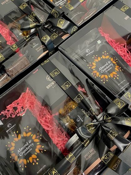 We created these custom corporate hampers for Runwal Realty, featuring their logo on a sleek black ribbon. The goal was an elegant and sophisticated gift, so we filled it with our gourmet Almond & Cranberry Granola and Spicy BBQ Almonds.