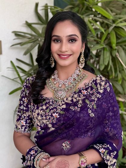 A glamorous look in a deep purple embroidered saree, paired with sparkling diamond jewellery.