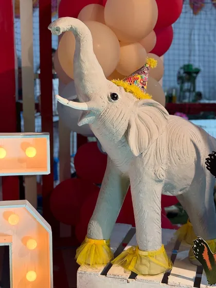 An adorable elephant prop wearing a party hat, adding to the whimsical and festive atmosphere of the circus celebration.